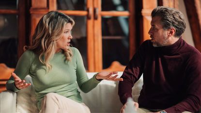 Adult man and woman sitting on a sofa, having a heated discussion