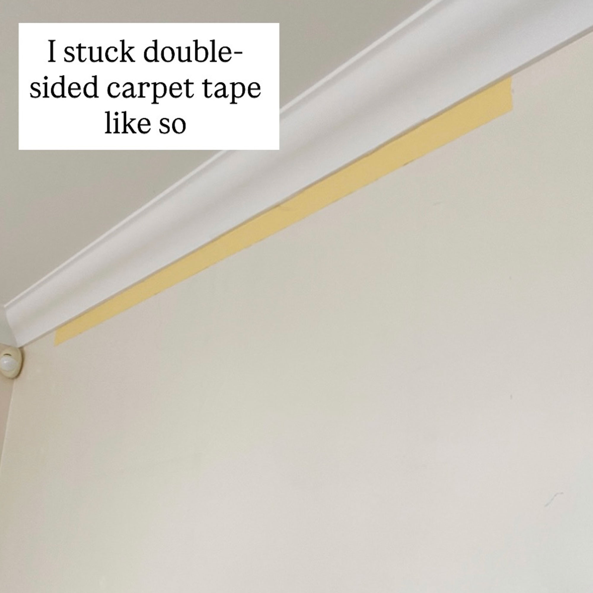 Mid DIY shot showing tape applied to wall near ceiling