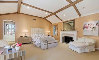 A bedroom with wall-to-wall carpeting and a bed and two sofas