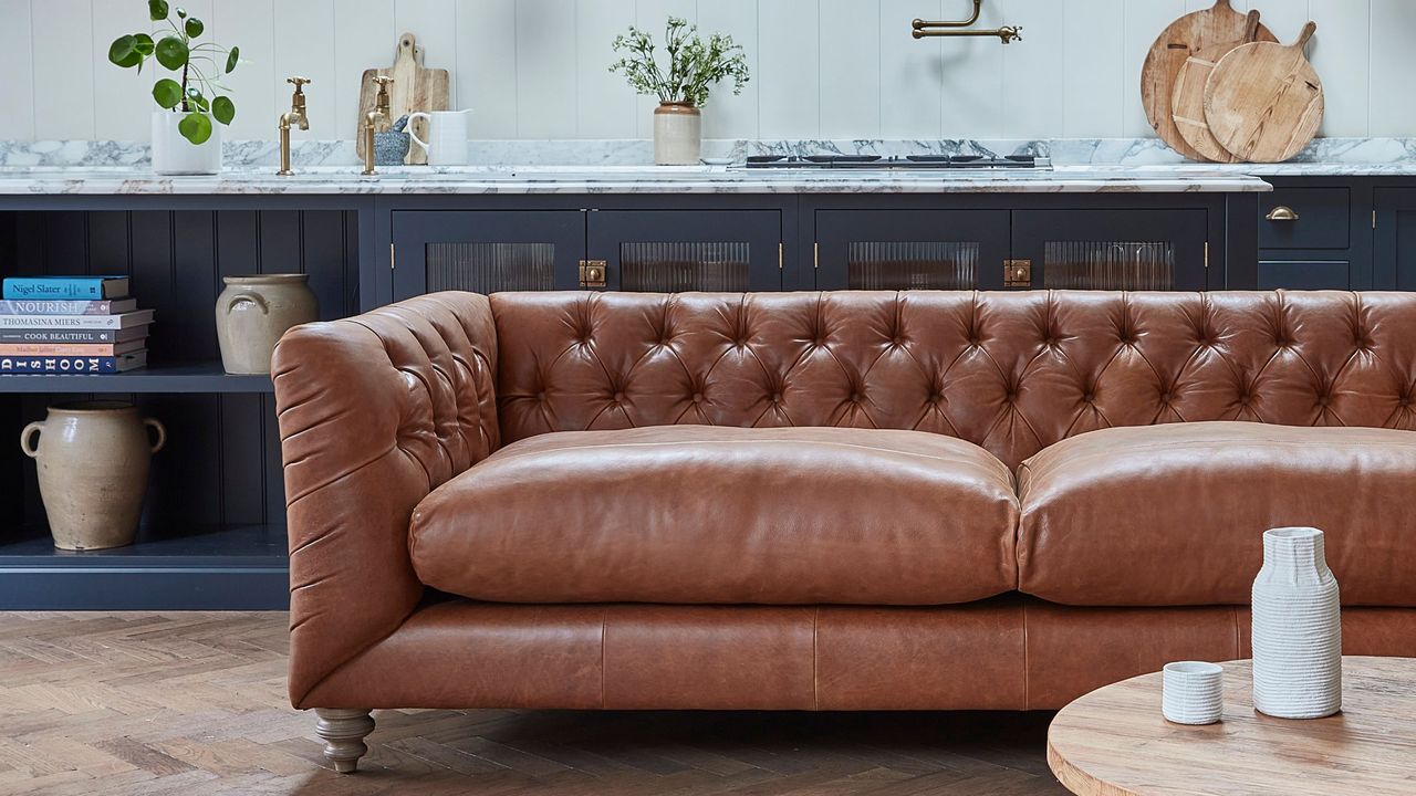 cognac sofa in open plan space with kitchen and coffee table