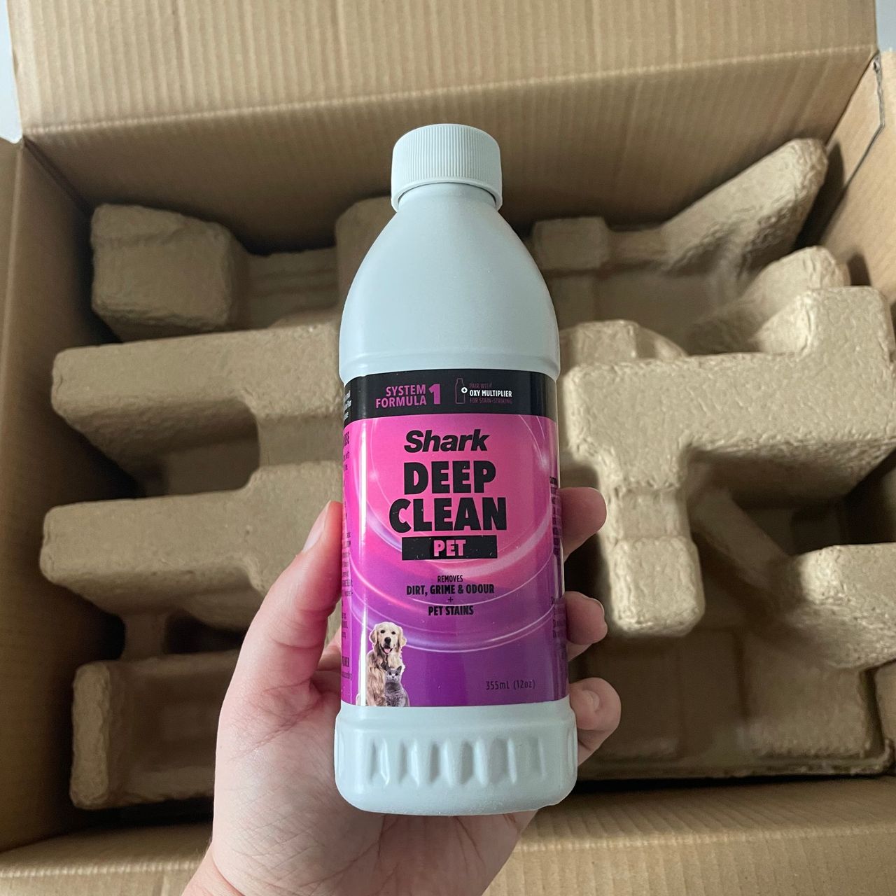 Shark CarpetXpert HairPro Pet Deep Carpet Cleaner with Spot Cleaner EX250UK box, with a hand holding deep cleaner bottle