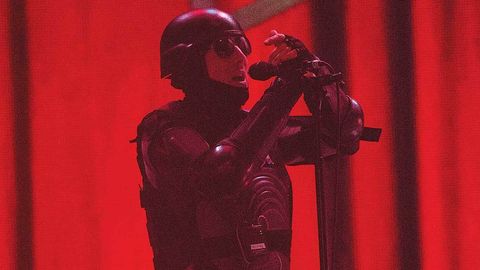 Maynard James Keenan on a red stage in a Robocop suit
