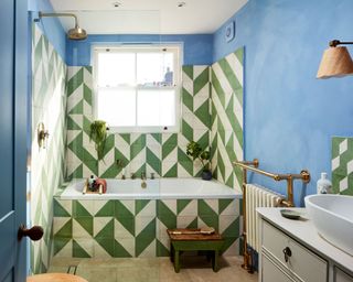 Bathroom with statement geometric green and white tile design on bathtub and walls