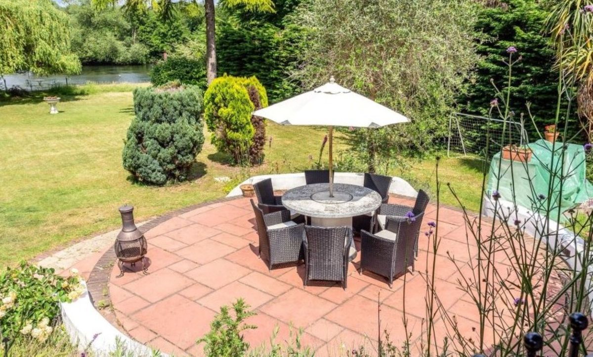 The patio overlooks the garden and the surrounding Thames