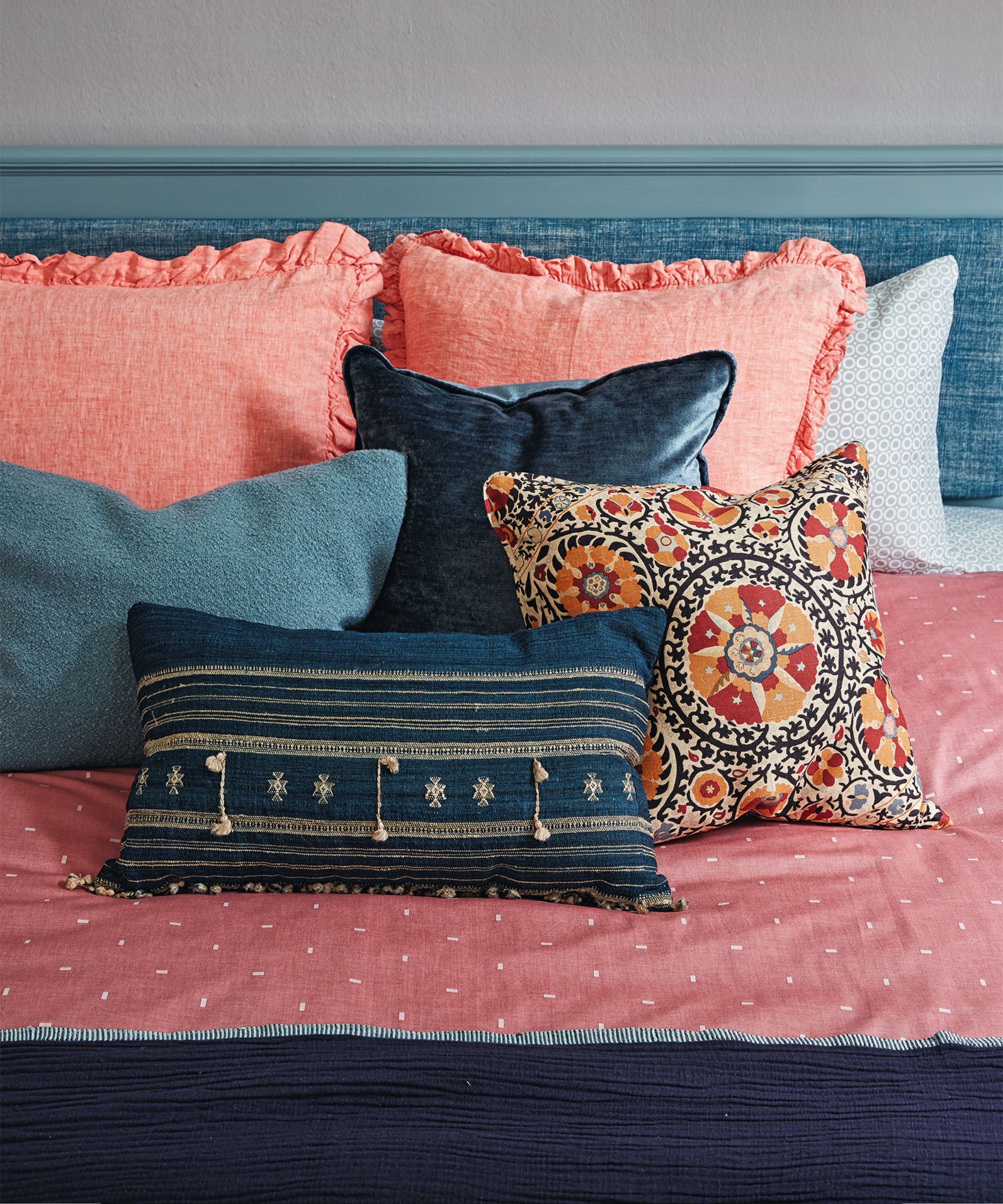 A colorful bed with throw pillows and cushions