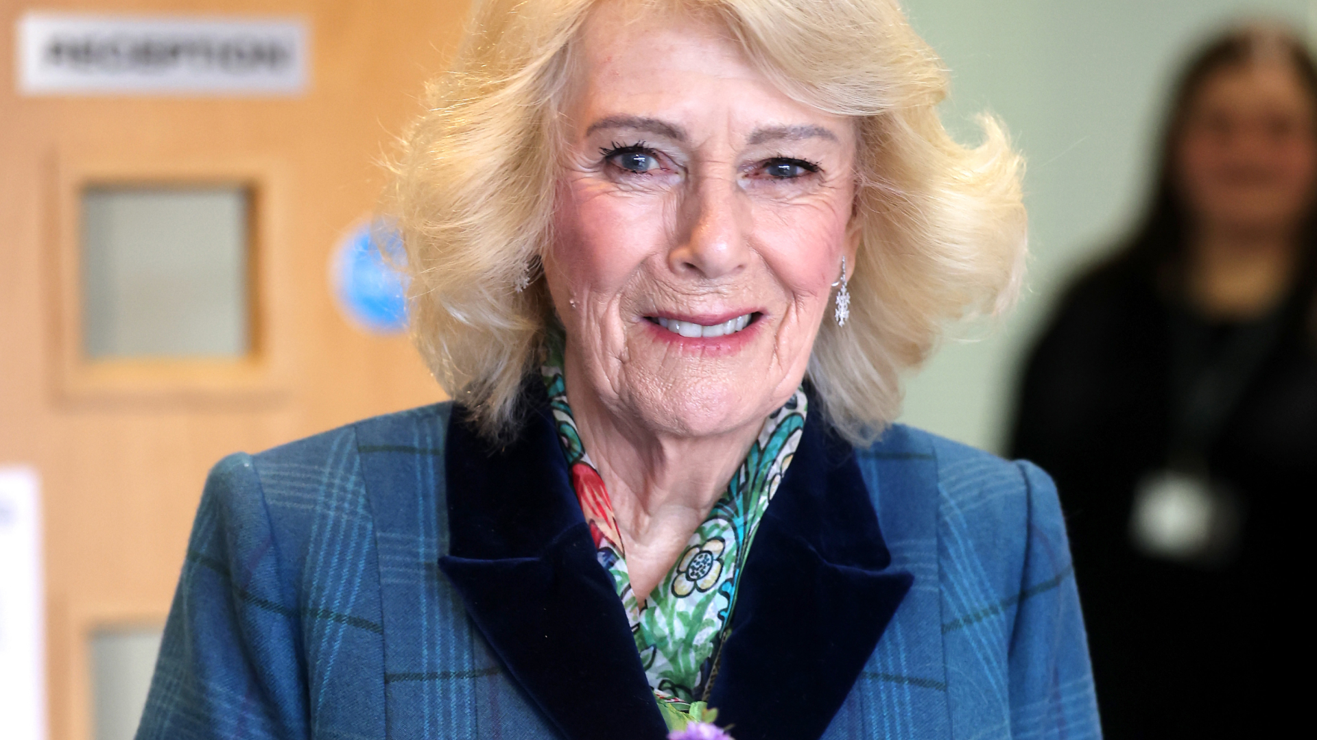 Queen Camilla wears a blue coat and floral scarf