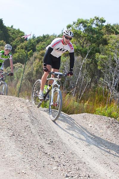 A rider stands to shift his weight on the downhill.