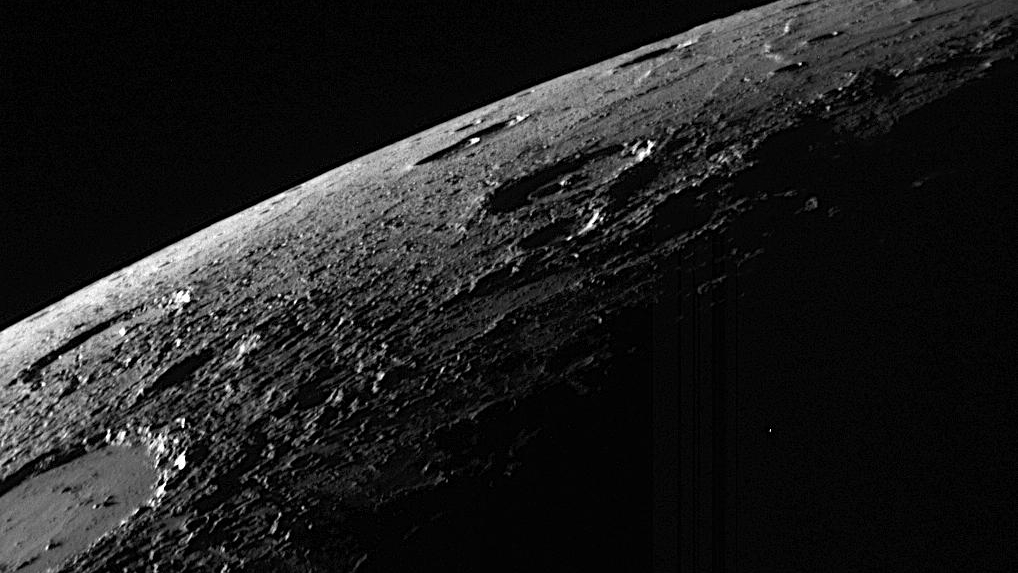 Vista en blanco y negro de parte de un planeta cubierto de cráteres.