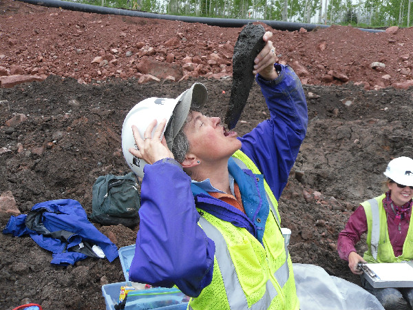 Volunteer digger Sandy Jackson, of Colorado Mountain College, enjoys a celebratory drink of water released from the first mastodon bone she uncovered. This drink from the first bone they uncovered from the ancient lake site was a rite of passage for diggers.