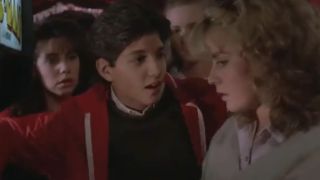 Ralph Machio talking to Elizabeth Shue as she plays a video game in The Karate Kid