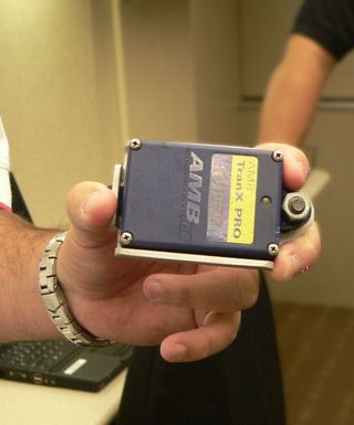 Steve Worling shows an AMB TranX Pro RFID transponder device, which is mounted behind each race car.