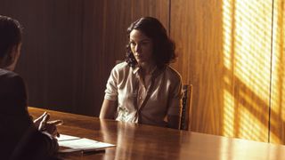 Kate looking upset as she sits at a table in the police station