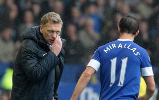 Everton's Scottish manager David Moyes (L) speaks with Everton's Belgian striker Kevin Mirallas (R) during their 2-0 win in the English Premier League football match between Everton and West Ham United at Goodison Park in Liverpool, north-west England, on May 12, 2013. David Moyes's final home match as Everton manager ended in a 2-0 Premier League victory over West Ham on Sunday thanks to two goals from Kevin Mirallas. Moyes, who will replace Alex Ferguson in charge of English champions Manchester United at the end of the season following the retirement of his fellow Scot, was applauded by all four stands before-kick off and had his name sung throughout by Everton fans in recognition of his 11 years as the Merseysiders' manager. AFP PHOTO / LINDSEY PARNABY RESTRICTED TO EDITORIAL USE. No use with unauthorized audio, video, data, fixture lists, club/league logos or “live” services. Online in-match use limited to 45 images, no video emulation. No use in betting, games or single club/league/player publications (Photo credit should read LINDSEY PARNABY/AFP via Getty Images)