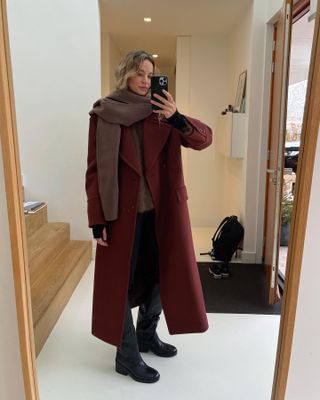 Influencer wears a burgundy coat.