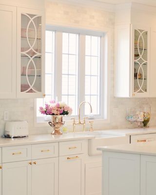 A kitchen with white cabinets with overlays on top
