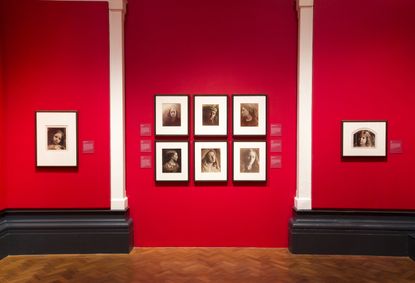 Red wall with old framed photographs