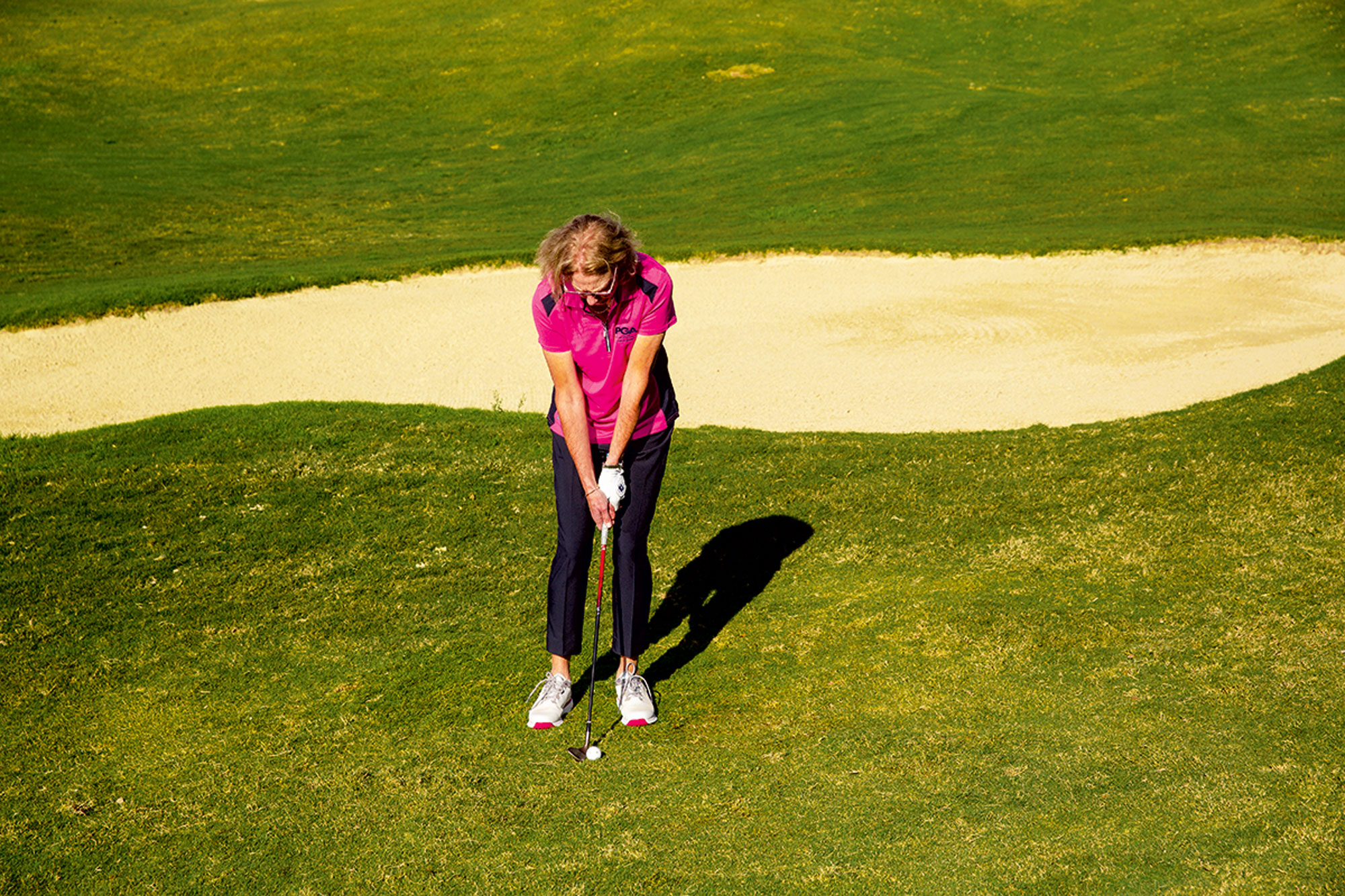 Sarah Bennett demonstrating the correct setup for chipping to a raised green, with hands slightly forward