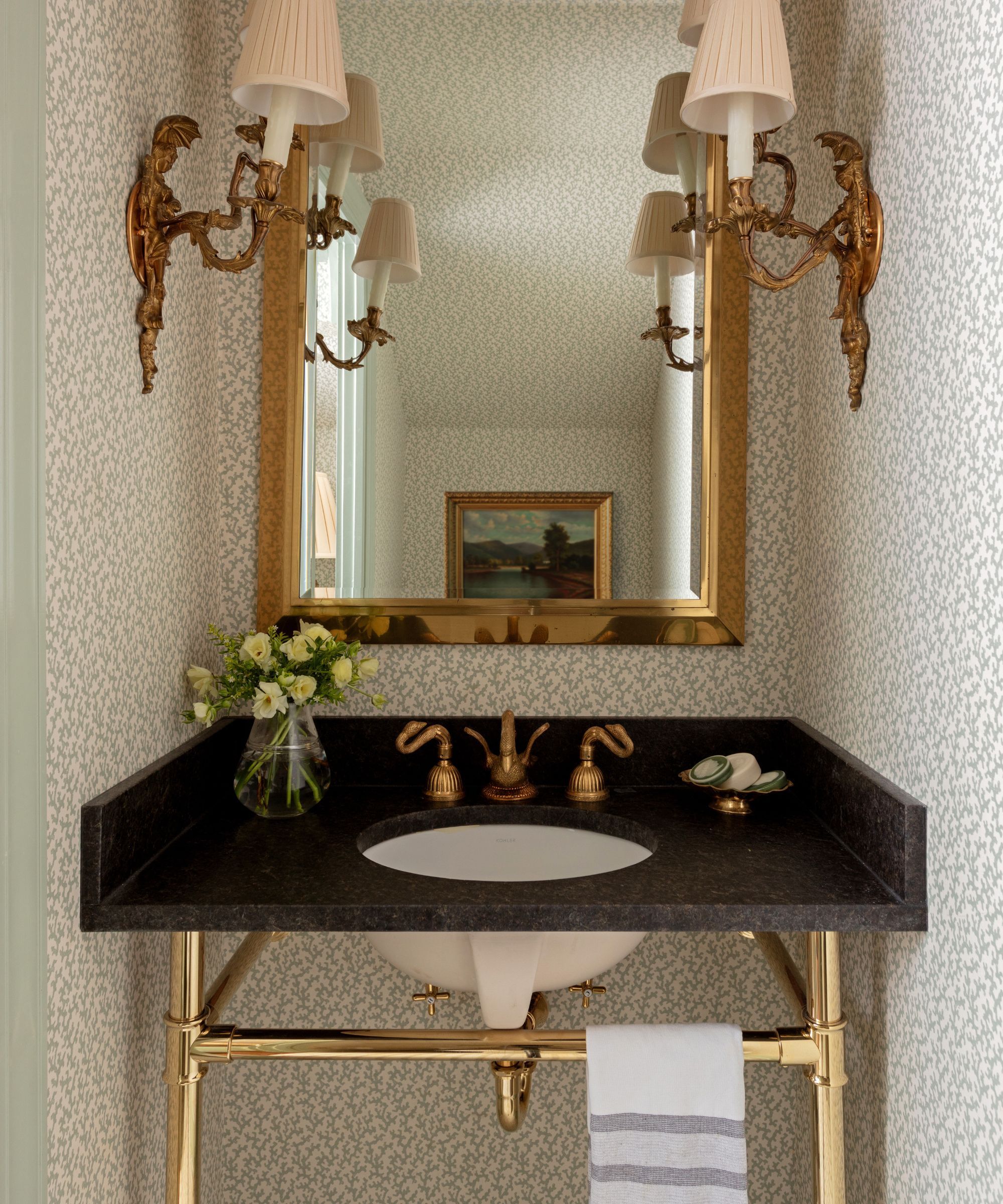 A bathroom sink with pale blue wallpaper