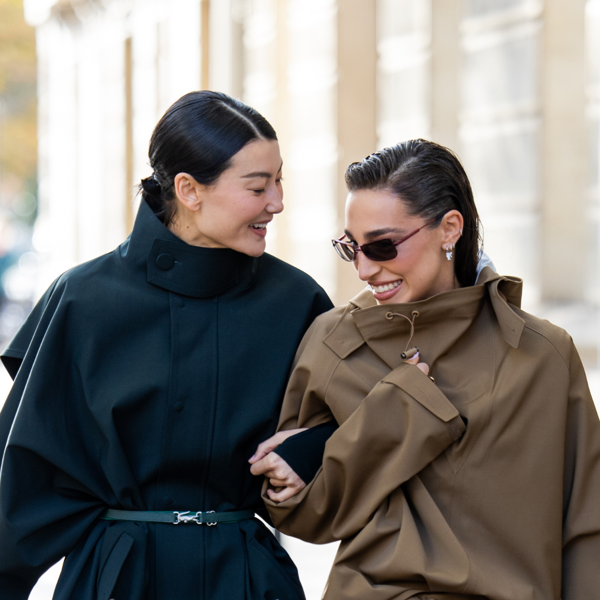 malachite skincare Amalie Gassmann wears black belted coat, blue bag &amp; Ginevra Mavilla wears brown skirt, jacket, silver bag, white heels, sunglasses outside Lacoste during the Womenswear Spring Summer 2026 as part of Paris Fashion Week on October 05, 2025