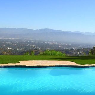 swimming pool with grass lawn and view of mountains