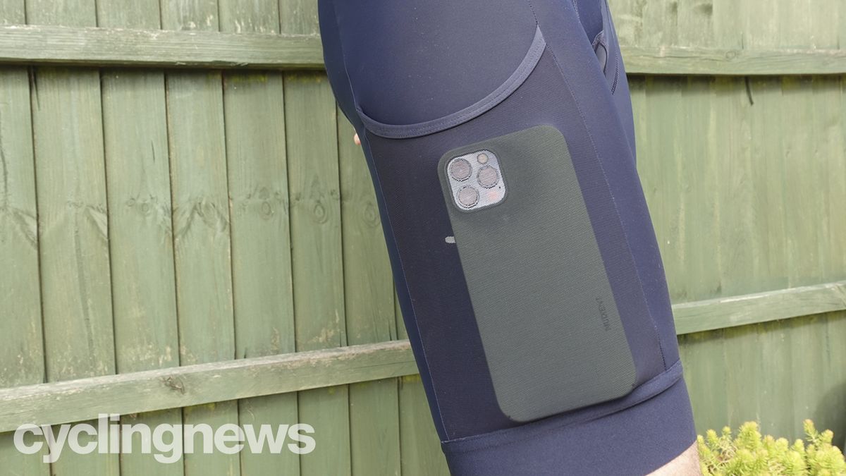Close up of right leg pocket on Rapha Core Cargo bib shorts, filled with iphone 12 to show capacity