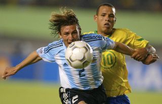 Argentina's Gabriel Heinze competes for the ball with Brazil's Luis Fabiano in a World Cup qualifier in June 2004.