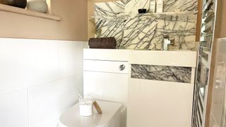 baking soda on a closed toilet lid in power room with marble backsplash