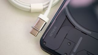 Looking closely at the back of the Nothing Phone (2) alongside the included transparent USB-C cable