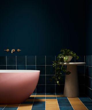 dark contrast bathroom with pink bath and yellow and indigo floor tiles