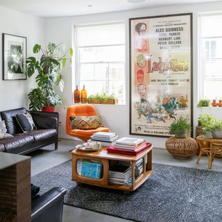 Mid-century styled living room with open coffee table, movie poster and rounded orange armchair