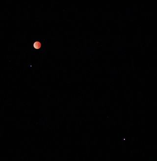 This wide angle view of the April 15, 2014 total lunar eclipse by Victor Rogus shows the bright star Spica and Mars as well as the eclipsed moon as seen from Jadwin, Missouri.