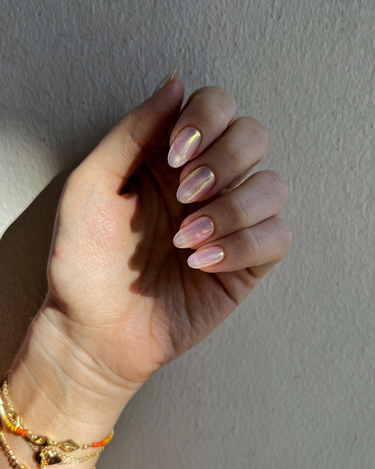Person wearing opal-glazed jelly nails.