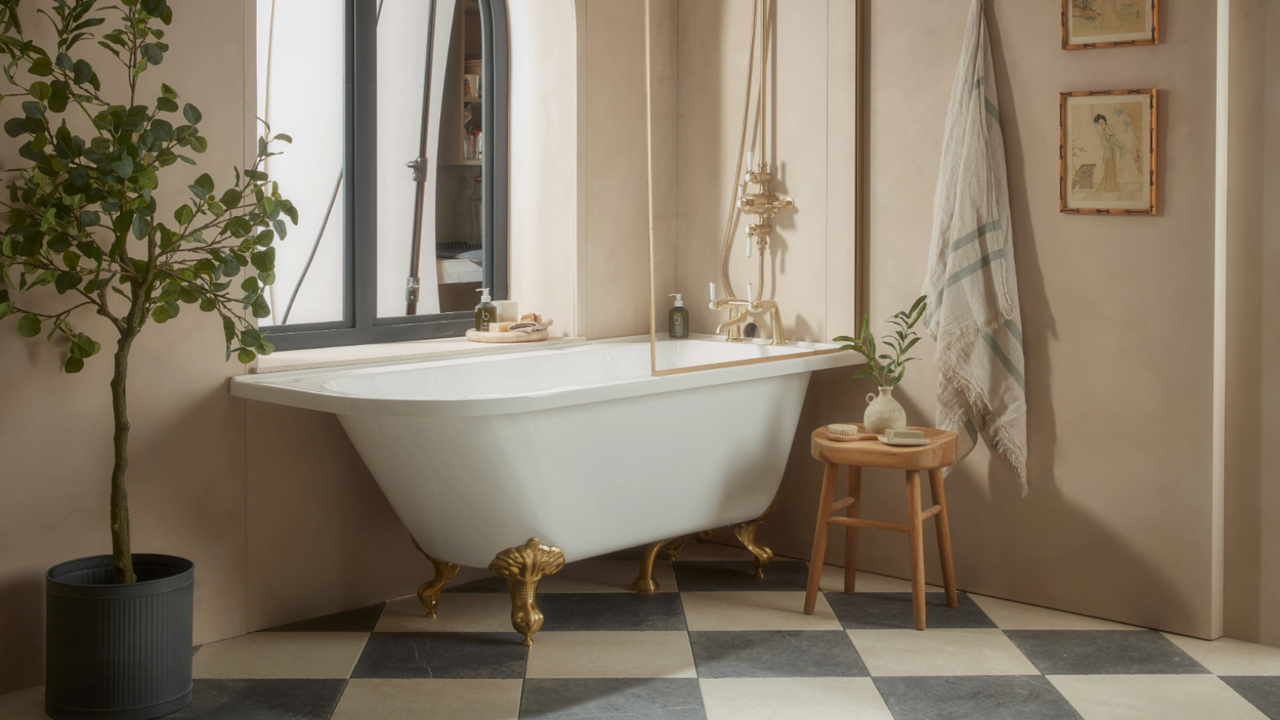 Neutral bathroom with freestanding bath, plant, beige walls, and patterned flooring