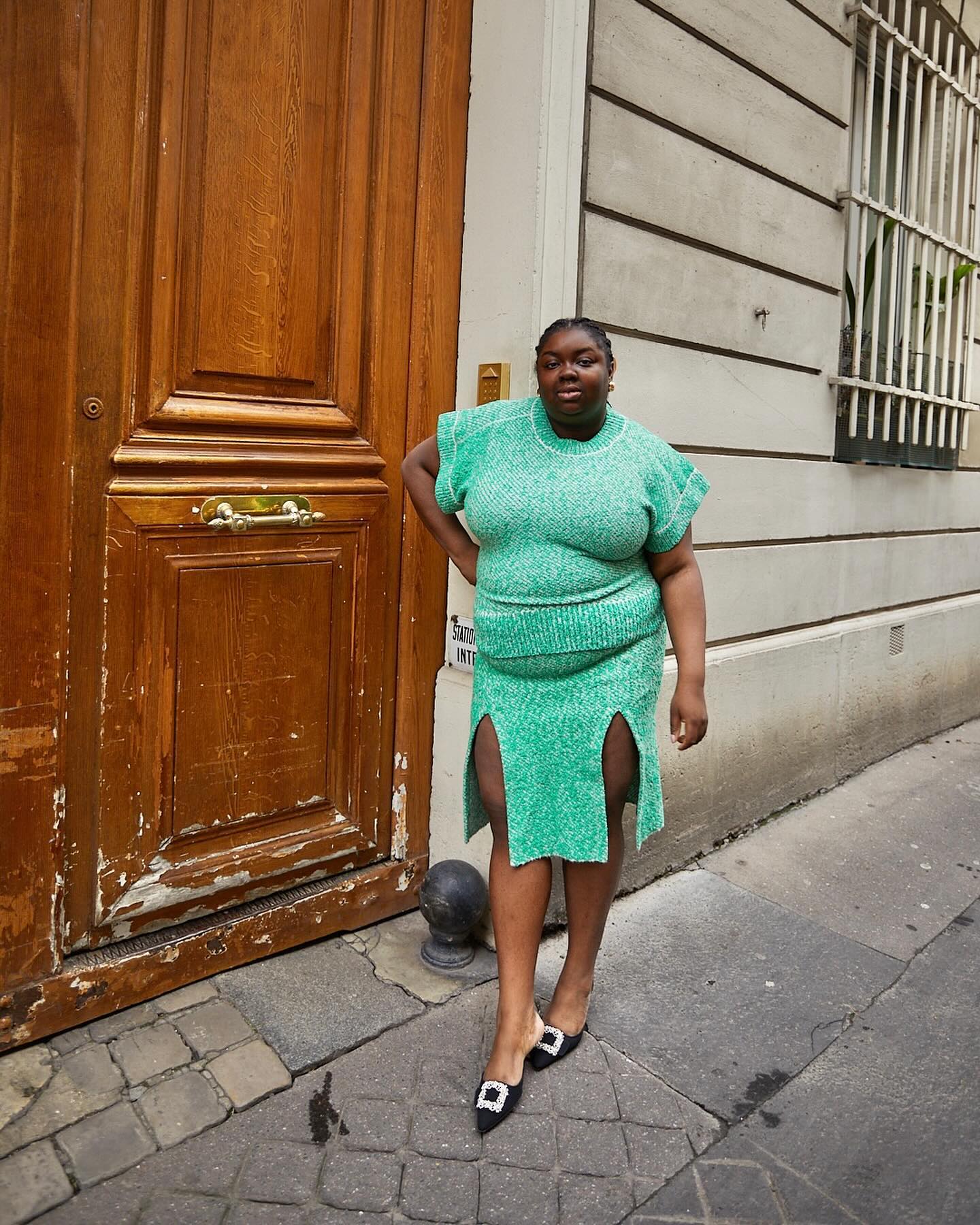 Abi Omole wearing a mint-green knit top and skirt set.