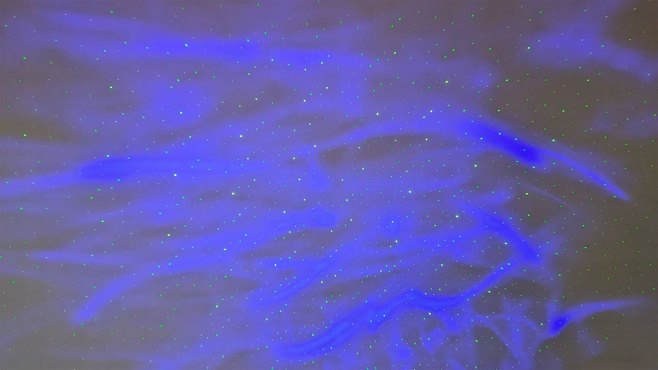 YgiTK Northern Galaxy Lights Projector during Review, on a wooden table against a dark coloured wall