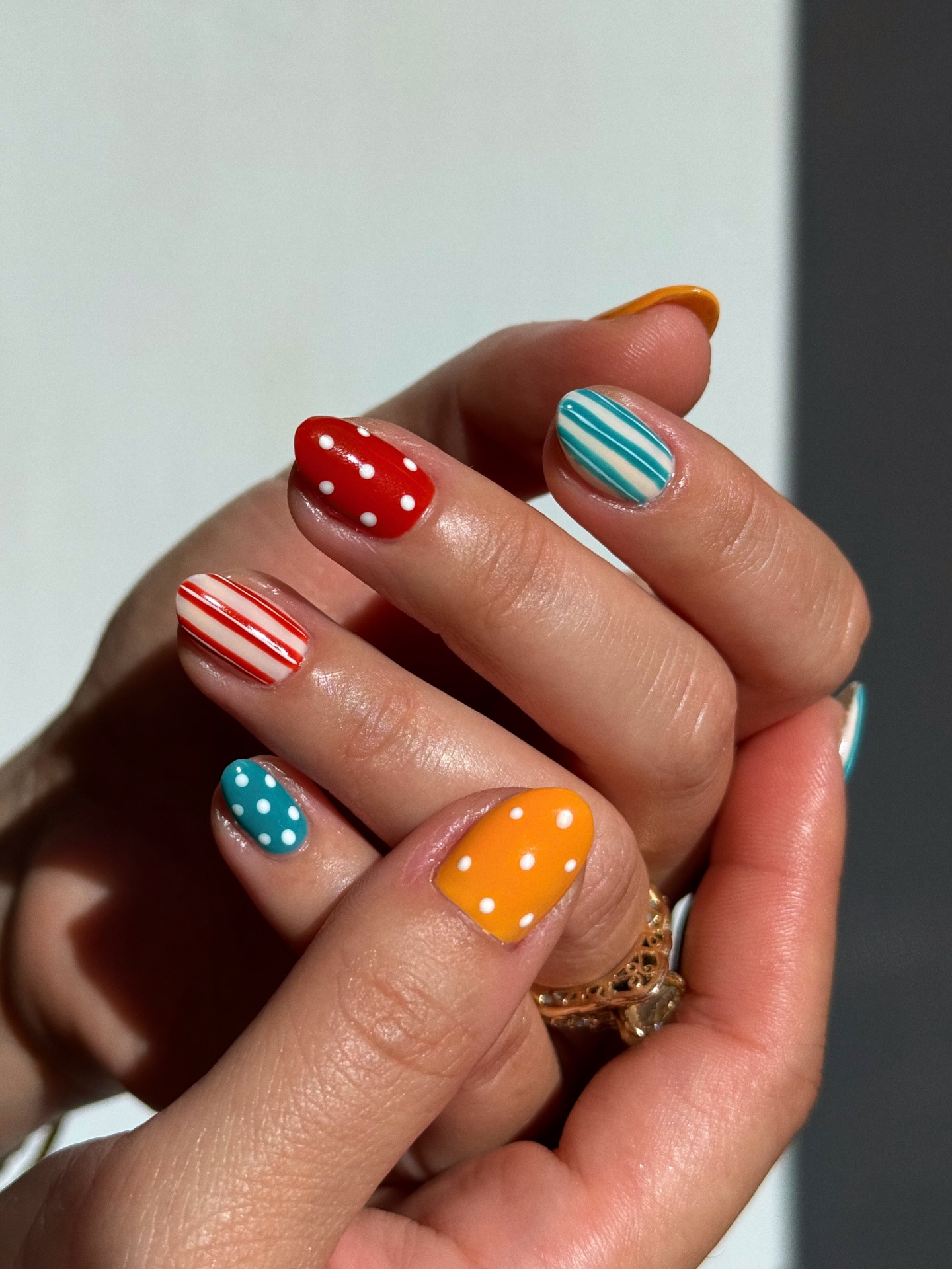 A manicure with polka dots and stripes by Queenie Nguyen
