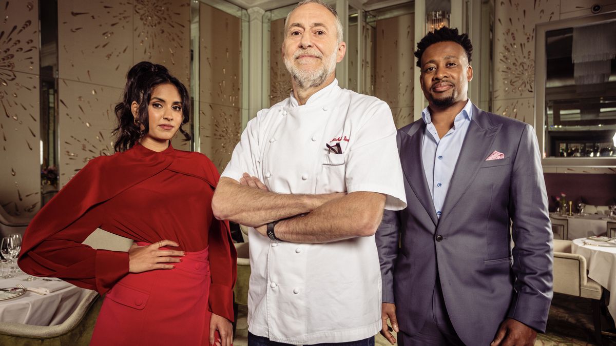 Ravneet Gill in a red top and skirt, Michel Roux Jr in chefs&#039; white and Mike Reid in a dark suit in Five Star Kitchen