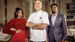 Ravneet Gill in a red top and skirt, Michel Roux Jr in chef whites and Mike Reid in a dark suit in Five Star Kitchen