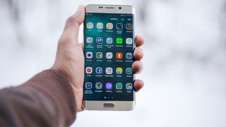 Bästa Android-mobil: En person som håller upp en Samsung-mobil mot en ljus bakgrund