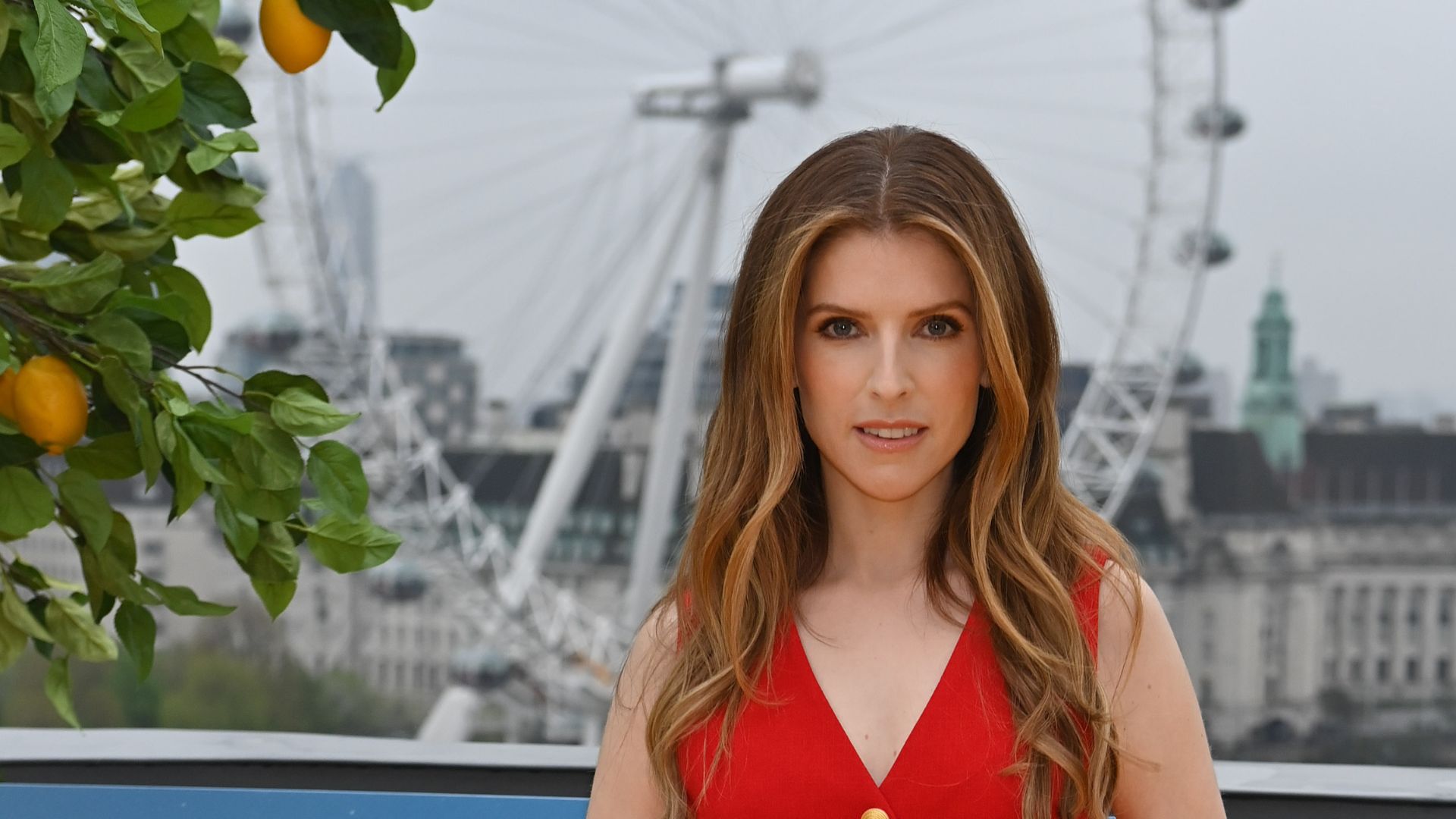 a headshot of anna kendrick wearing red