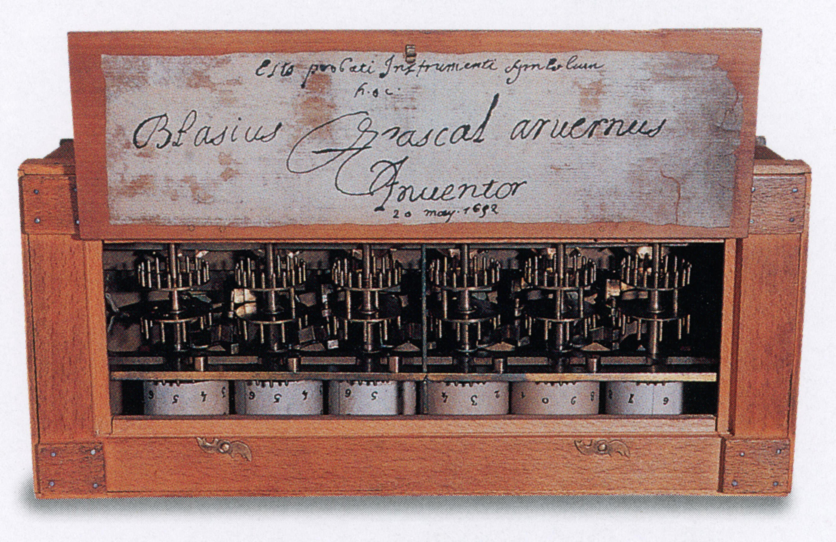 Showing the inside of a Pascaline mechanical calculator invented by Blaise Pascal in 1642. The wheels are numbered from 0-10 and correspond to units, tens, hundreds, thousands, tens of thousands, and hundreds of thousands.
