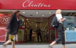 A Clintons card shop with two people walking in front