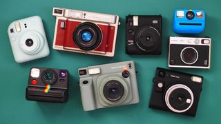 A selection of Instax, Polaroid and Lomography instant cameras, against a teal background