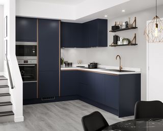 A navy kitchen with copper accents and copper light fixtures