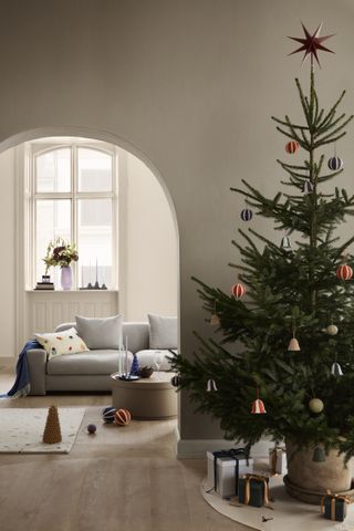 A living room with a christmas tree outside it