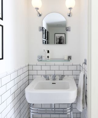 Ideas for small bathrooms showing a small sink in front of small white metro tiles on the wall