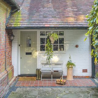 small front porch ideas, country cottage with yellow front door, bench outside