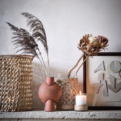 Stone shelf with artwork, candle and vases