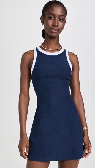 a model wears a navy tennis dress with white piping 