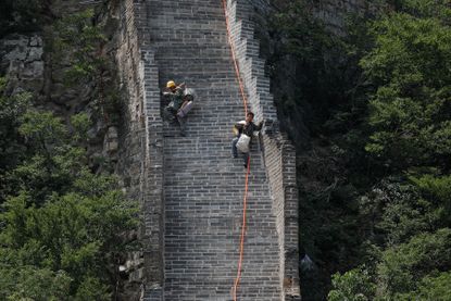 Construction workers climb down the Great Wall of China.